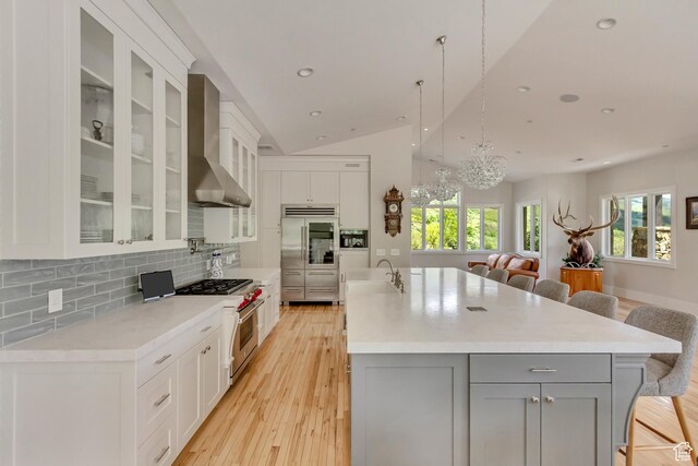 370 S Got Teeth Ln E, Emigration Canyon, UT 84108 - kitchen with premium appliances, wall chimney range hood, gray cabinets, a breakfast bar, and open floor plan