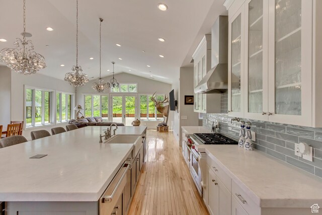 370 S Got Teeth Ln E, Emigration Canyon, UT 84108 - kitchen featuring wall chimney range hood, double oven range, a chandelier, open floor plan, and vaulted ceiling