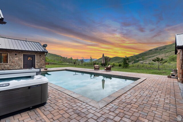 370 S Got Teeth Ln E, Emigration Canyon, UT 84108 - pool at dusk featuring a patio, a mountain view, an outdoor pool, and a hot tub