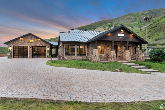 370 S Got Teeth Ln E, Emigration Canyon, UT 84108 - view of front of house featuring stone siding, a standing seam roof, a garage, decorative driveway, and a lawn