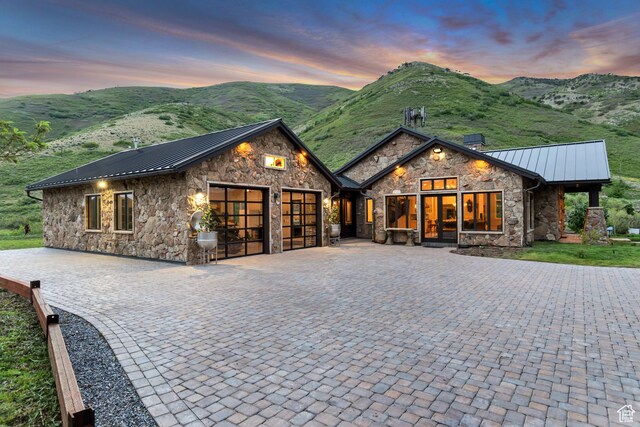 370 S Got Teeth Ln E, Emigration Canyon, UT 84108 - view of front facade with stone siding, a standing seam roof, an attached garage, and a metal roof