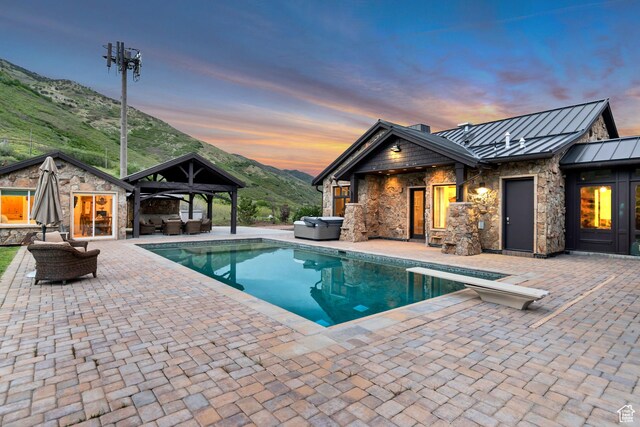 370 S Got Teeth Ln E, Emigration Canyon, UT 84108 - pool at dusk featuring a hot tub, a gazebo, an outdoor hangout area, and an outdoor pool