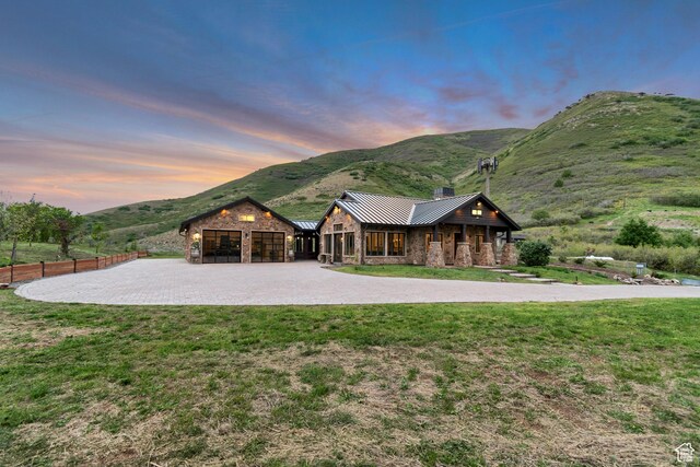 370 S Got Teeth Ln E, Emigration Canyon, UT 84108 - view of front of home with curved driveway, stone siding, a garage, a mountain view, and a standing seam roof