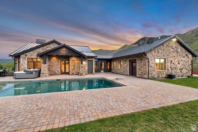 370 S Got Teeth Ln E, Emigration Canyon, UT 84108 - rear view of property with a hot tub, a standing seam roof, a patio area, stone siding, and an outdoor pool