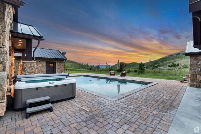 370 S Got Teeth Ln E, Emigration Canyon, UT 84108 - pool at dusk with a patio, a mountain view, a hot tub, and an outdoor pool
