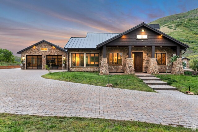370 S Got Teeth Ln E, Emigration Canyon, UT 84108 - view of front of home featuring stone siding, decorative driveway, a front yard, a standing seam roof, and an attached garage