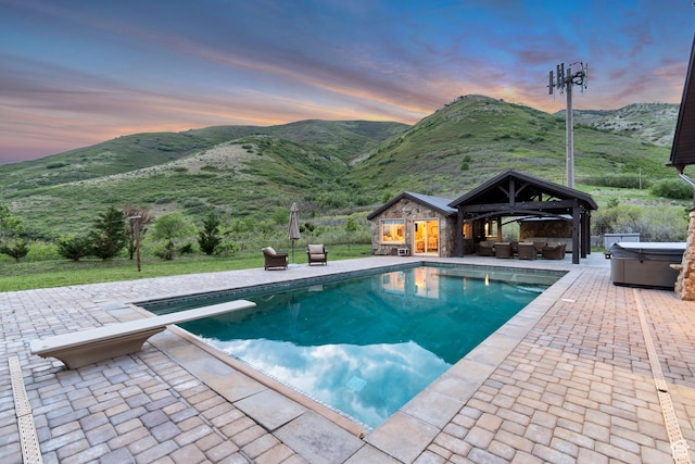 370 S Got Teeth Ln E, Emigration Canyon, UT 84108 - pool at dusk with a hot tub, an outdoor hangout area, a patio area, an outdoor pool, and a mountain view
