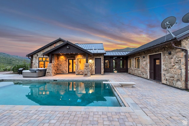 370 S Got Teeth Ln E, Emigration Canyon, UT 84108 - rear view of house with a hot tub, a standing seam roof, a patio area, stone siding, and an outdoor pool