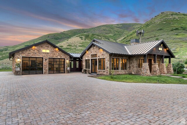370 S Got Teeth Ln E, Emigration Canyon, UT 84108 - view of front facade featuring a standing seam roof, stone siding, an attached garage, a metal roof, and a mountain view