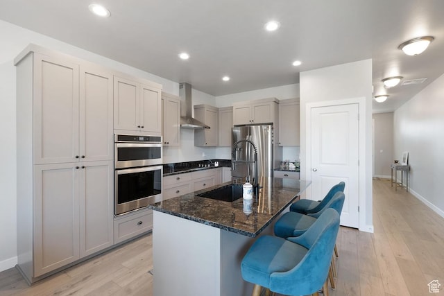 1308 E Daffodil Ct Unit 150, Layton, UT 84040 - kitchen with wall chimney range hood, appliances with stainless steel finishes, a breakfast bar area, light wood-style flooring, and recessed lighting