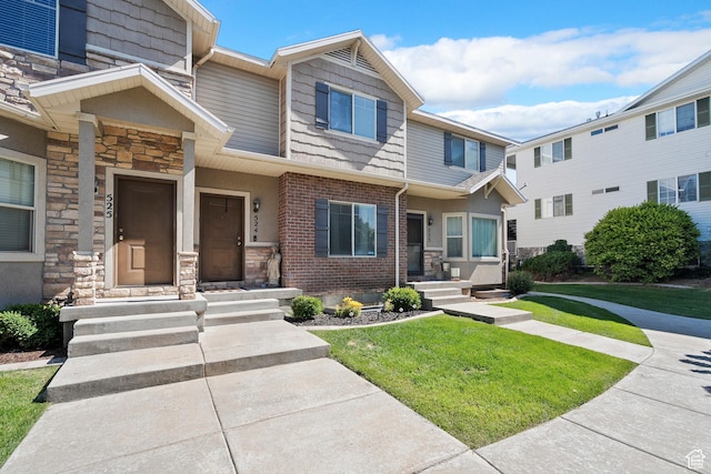 490 E 700 S Unit 524, Clearfield, UT 84015 - view of property featuring stone siding and a front lawn
