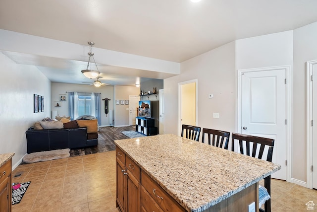 490 E 700 S Unit 524, Clearfield, UT 84015 - kitchen with brown cabinetry, ceiling fan, decorative light fixtures, and light stone countertops