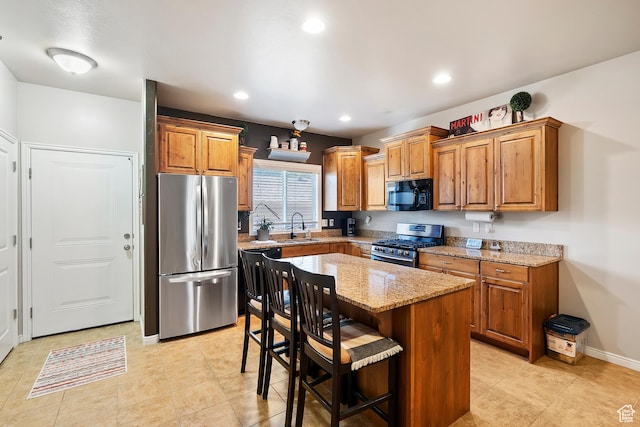 490 E 700 S Unit 524, Clearfield, UT 84015 - kitchen with stainless steel appliances, light stone counters, brown cabinetry, a kitchen bar, and recessed lighting