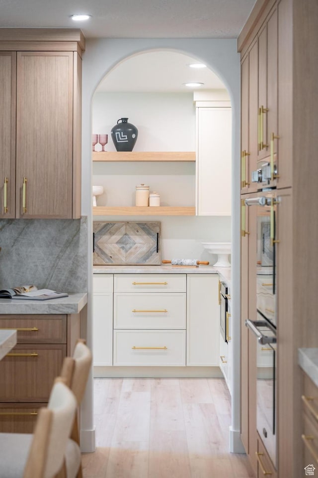 2795 E Palma Way, Cottonwood Heights, UT 84121 - kitchen with arched walkways, light wood finished floors, light countertops, stainless steel double oven, and recessed lighting