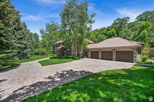 5757 S Holladay Blvd E, Holladay, UT 84121 - view of front of home with decorative driveway, a front yard, a tile roof, an attached garage, and stucco siding