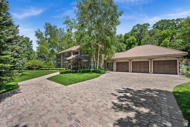 5757 S Holladay Blvd E, Holladay, UT 84121 - view of front facade with a tiled roof, driveway, a front lawn, an attached garage, and stucco siding