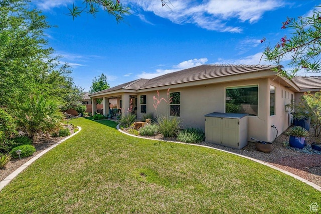 3075 E Delany Dr, St George, UT 84790 - rear view of property with stucco siding, a tiled roof, and a yard