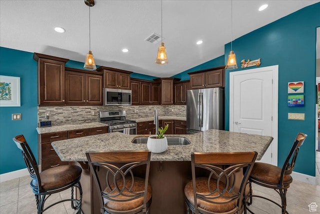 3075 E Delany Dr, St George, UT 84790 - kitchen featuring stainless steel appliances, tasteful backsplash, dark brown cabinets, a breakfast bar area, and lofted ceiling