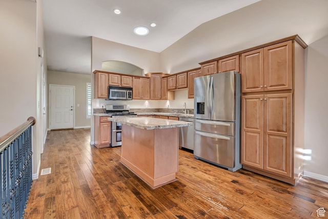 9656 Villa Springs Cv, Sandy, UT 84070 - kitchen with stainless steel appliances, a kitchen island, wood-type flooring, high vaulted ceiling, and light stone countertops