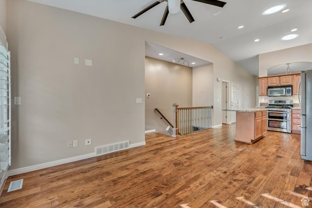 9656 Villa Springs Cv, Sandy, UT 84070 - kitchen featuring appliances with stainless steel finishes, a center island, light wood-type flooring, a ceiling fan, and vaulted ceiling