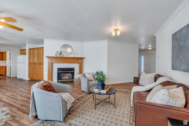 2522 N 1000 E, Provo, UT 84604 - living room featuring light wood-type flooring, a ceiling fan, a tiled fireplace, and crown molding