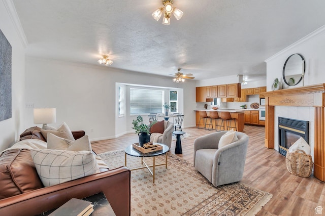 2522 N 1000 E, Provo, UT 84604 - living room with a ceiling fan, light wood finished floors, ornamental molding, and a tiled fireplace