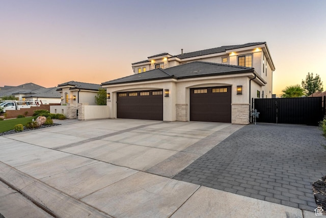 2530 S Monterosa Ln, St George, UT 84790 - prairie-style house featuring driveway, an attached garage, a gate, stucco siding, and stone siding