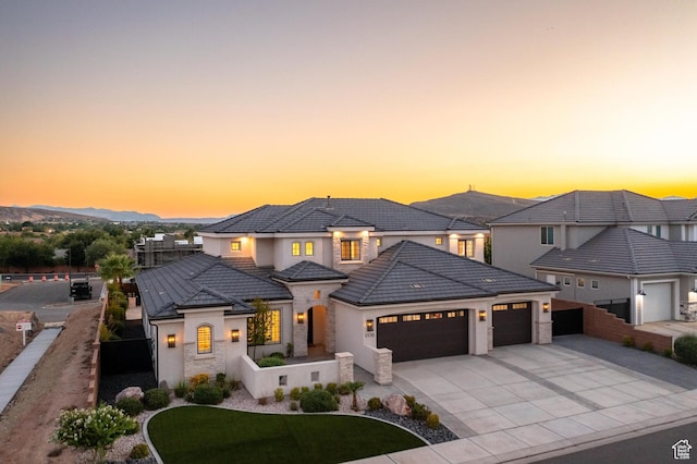 2530 S Monterosa Ln, St George, UT 84790 - view of front of property with an attached garage, driveway, stucco siding, stone siding, and a tile roof
