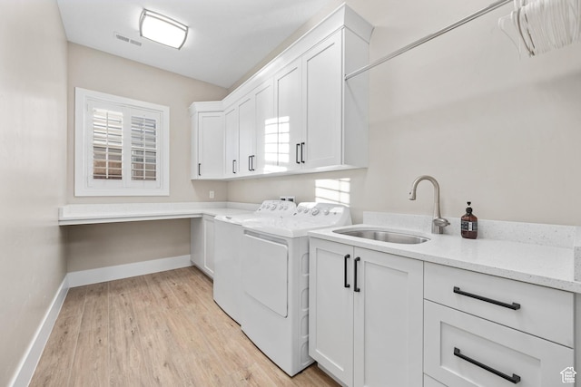 2530 S Monterosa Ln, St George, UT 84790 - laundry room featuring cabinet space, washer and dryer, light wood finished floors, and healthy amount of natural light