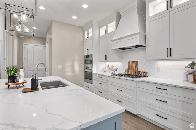 2530 S Monterosa Ln, St George, UT 84790 - kitchen with custom exhaust hood, a chandelier, decorative backsplash, white cabinets, and recessed lighting