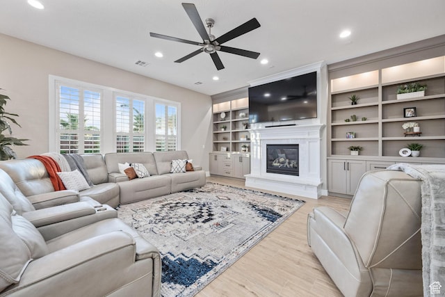 2530 S Monterosa Ln, St George, UT 84790 - living room featuring a ceiling fan, light wood-type flooring, a glass covered fireplace, recessed lighting, and built in features