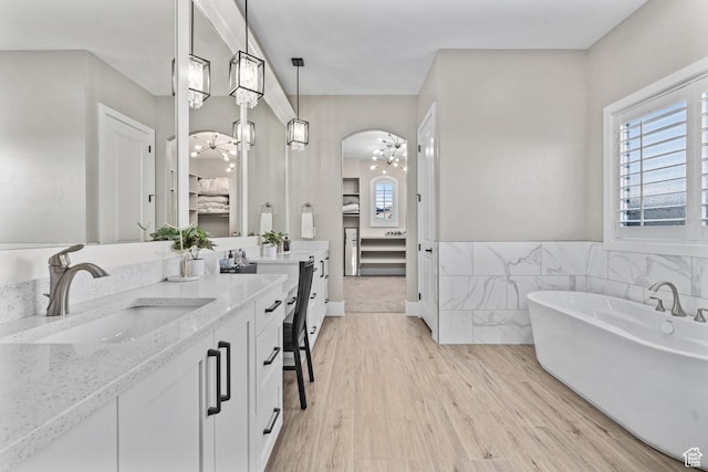 2530 S Monterosa Ln, St George, UT 84790 - bathroom with vanity, a freestanding tub, wood finished floors, and ensuite bath