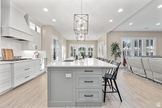 2530 S Monterosa Ln, St George, UT 84790 - kitchen featuring premium range hood, a chandelier, light wood-type flooring, white gas stovetop, and recessed lighting