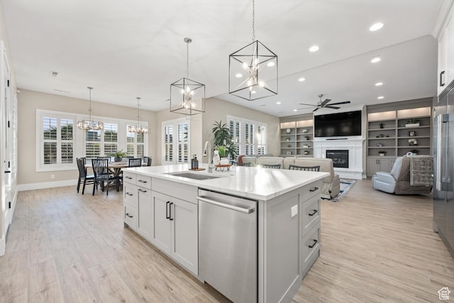 2530 S Monterosa Ln, St George, UT 84790 - kitchen featuring dishwasher, a chandelier, ceiling fan, an island with sink, and a glass covered fireplace
