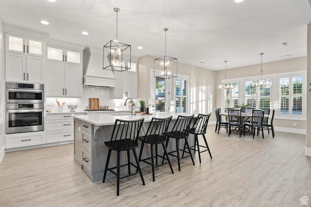 2530 S Monterosa Ln, St George, UT 84790 - kitchen with custom range hood, stainless steel double oven, a chandelier, recessed lighting, and light countertops