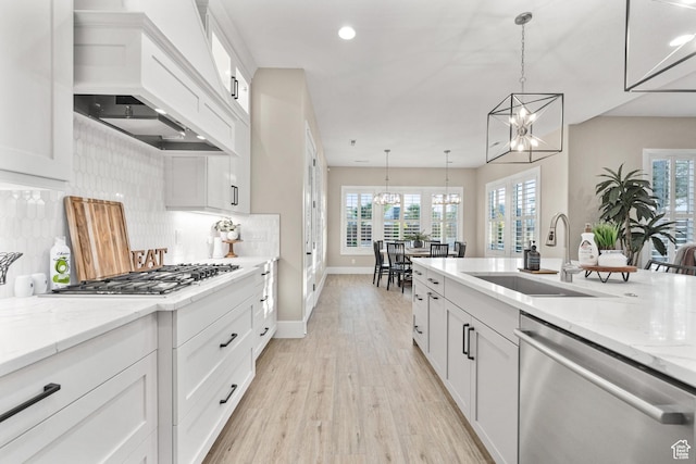 2530 S Monterosa Ln, St George, UT 84790 - kitchen featuring stainless steel appliances, custom exhaust hood, a chandelier, light wood-style flooring, and tasteful backsplash
