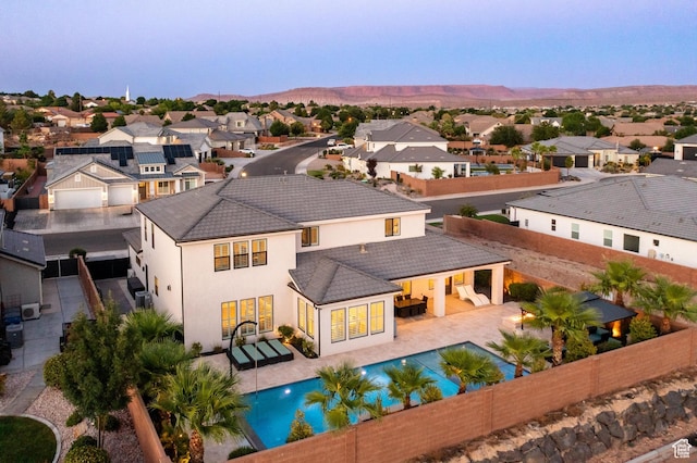 2530 S Monterosa Ln, St George, UT 84790 - rear view of house featuring a fenced backyard, a residential view, stucco siding, a mountain view, and a tile roof