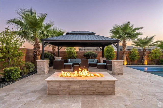 2530 S Monterosa Ln, St George, UT 84790 - patio terrace at dusk featuring a gazebo, an outdoor living space with a fire pit, a patio area, and a fenced backyard