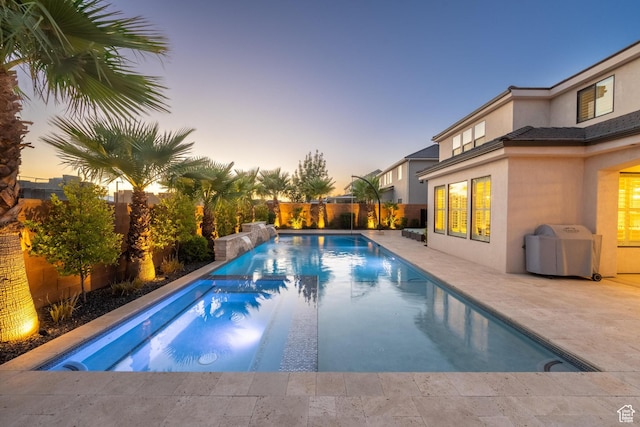 2530 S Monterosa Ln, St George, UT 84790 - pool at dusk with a pool with connected hot tub, a patio area, a fenced backyard, and grilling area