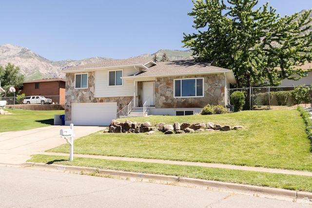 2908 N Cherry Dr E, North Ogden, UT 84414 - split level home with stone siding, concrete driveway, a mountain view, and a garage