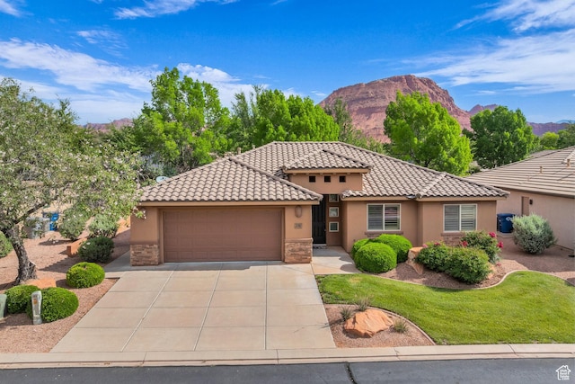 336 W 270 S, Ivins, UT 84738 - mediterranean / spanish house featuring stucco siding, an attached garage, concrete driveway, a mountain view, and stone siding