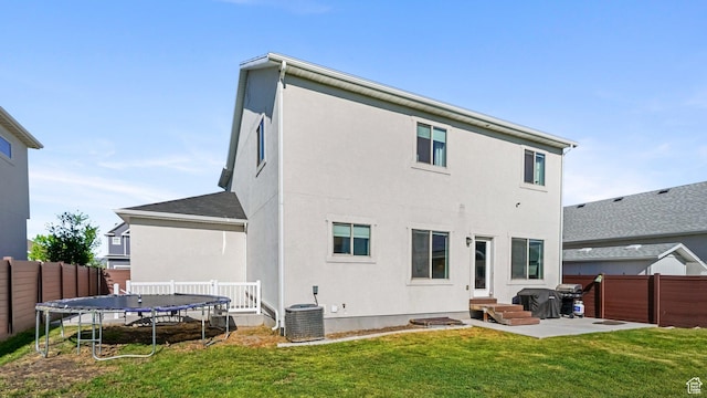312 N 240 E, Vineyard, UT 84059 - back of house featuring a trampoline, a fenced backyard, a patio, stucco siding, and entry steps