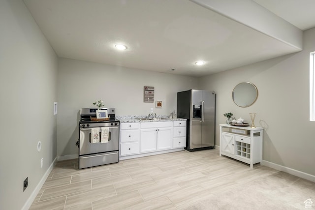 6459 N Star Discovery Way W, Stansbury Park, UT 84074 - kitchen with appliances with stainless steel finishes, white cabinetry, recessed lighting, light stone counters, and light wood-style floors