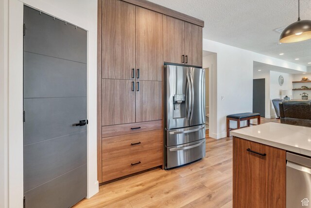113 N 1400 E, Pleasant Grove, UT 84062 - kitchen featuring appliances with stainless steel finishes, light wood-style floors, modern cabinets, open floor plan, and light countertops