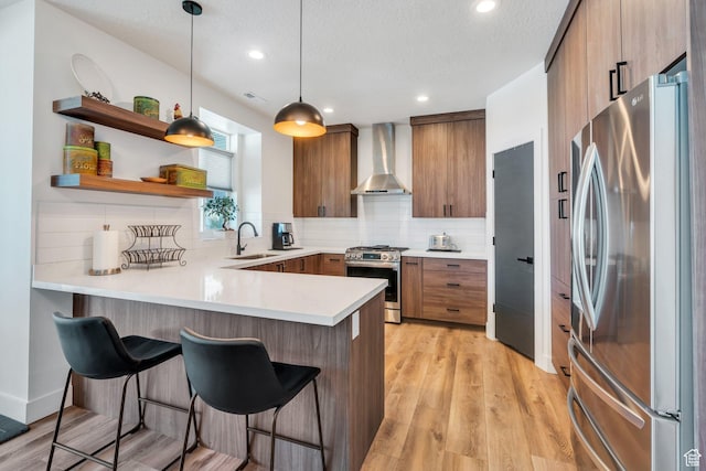 113 N 1400 E, Pleasant Grove, UT 84062 - kitchen with wall chimney exhaust hood, stainless steel appliances, a peninsula, a kitchen bar, and decorative backsplash