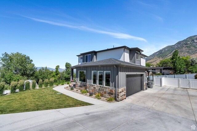 113 N 1400 E, Pleasant Grove, UT 84062 - view of front of home with board and batten siding, concrete driveway, a mountain view, and stone siding