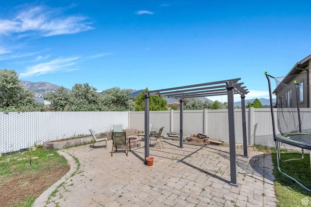 1198 N Reese Dr, Provo, UT 84601 - fenced backyard featuring a trampoline, a patio area, a pergola, and a mountain view
