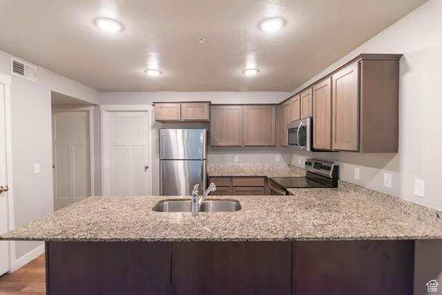 477 S 850 E, American Fork, UT 84003 - kitchen featuring appliances with stainless steel finishes, a peninsula, light stone countertops, recessed lighting, and wood finished floors