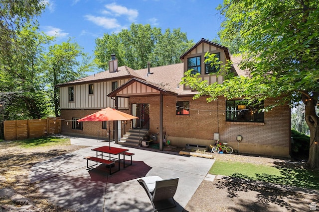 2673 E Toni Cir S, Cottonwood Heights, UT 84121 - back of property with a patio area, brick siding, a chimney, and roof with shingles