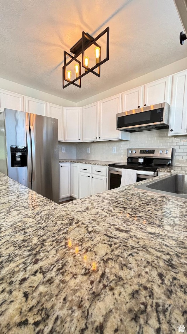 1165 N 2850 W, Provo, UT 84601 - kitchen with stainless steel appliances, white cabinets, tasteful backsplash, and stone countertops